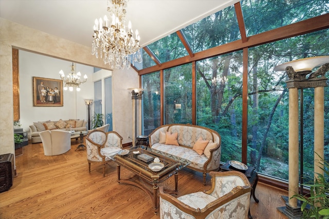 living room with hardwood / wood-style flooring, an inviting chandelier, floor to ceiling windows, and a healthy amount of sunlight