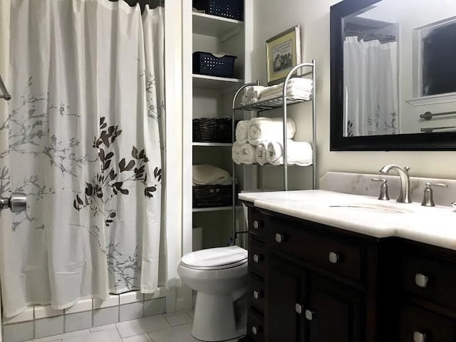 bathroom featuring tile patterned flooring, vanity, toilet, and walk in shower