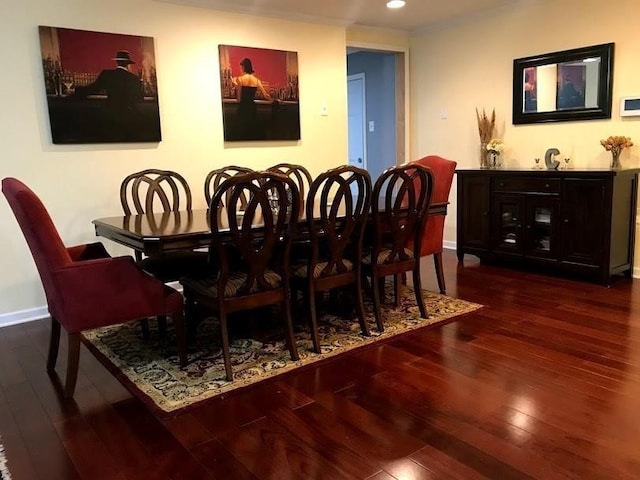 dining space with ornamental molding and dark wood-type flooring