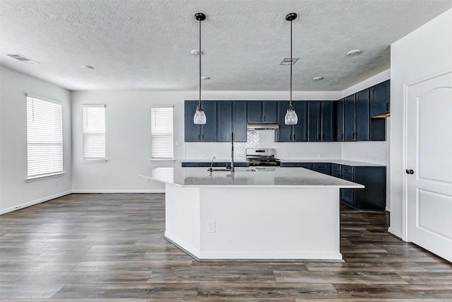25342 Trinity Oakley Ct, Katy, TX 77493 - kitchen featuring stainless steel range, a textured ceiling, tasteful backsplash, dark wood finished floors, and an island with sink