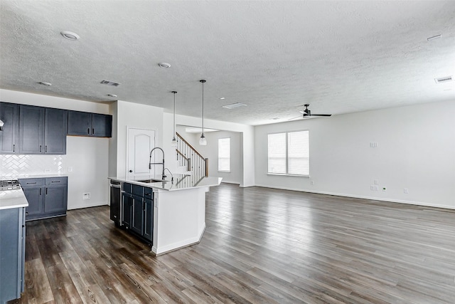 25342 Trinity Oakley Ct, Katy, TX 77493 - kitchen with a sink, a textured ceiling, dark wood-type flooring, open floor plan, and light countertops