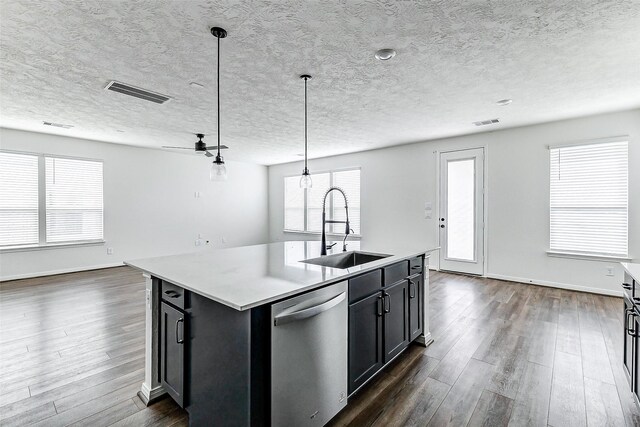 25342 Trinity Oakley Ct, Katy, TX 77493 - kitchen featuring stainless steel dishwasher, a sink, dark wood-style floors, light countertops, and hanging light fixtures
