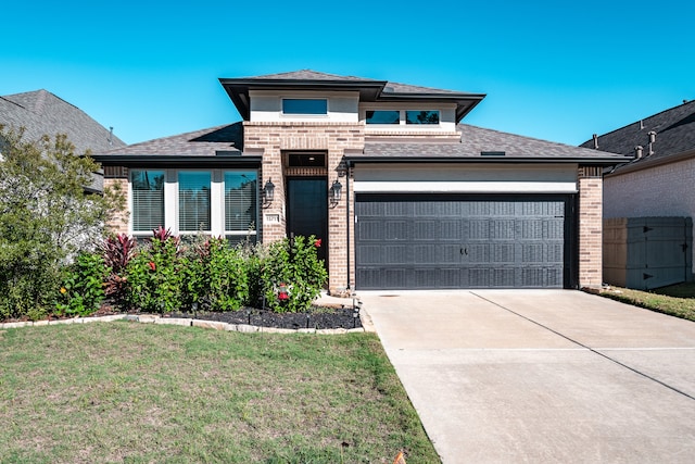 prairie-style house featuring a front yard and a garage