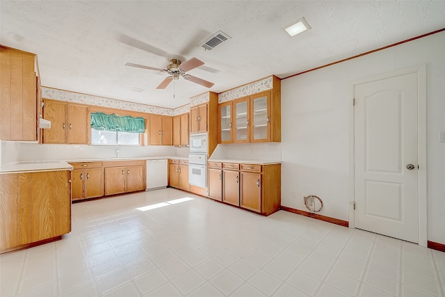 kitchen with white appliances, sink, ceiling fan, ornamental molding, and a textured ceiling