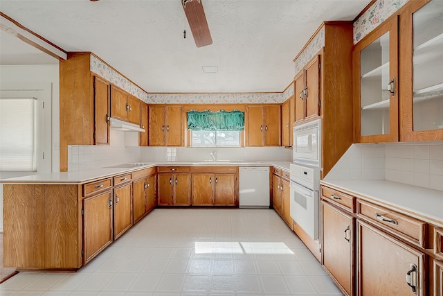 kitchen with backsplash, a textured ceiling, white appliances, ceiling fan, and sink