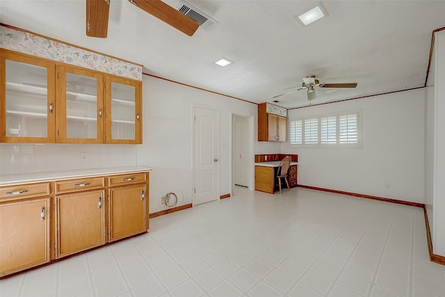 kitchen featuring ceiling fan, ornamental molding, and tasteful backsplash