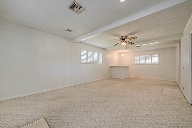 carpeted spare room with a textured ceiling, a wealth of natural light, crown molding, and ceiling fan