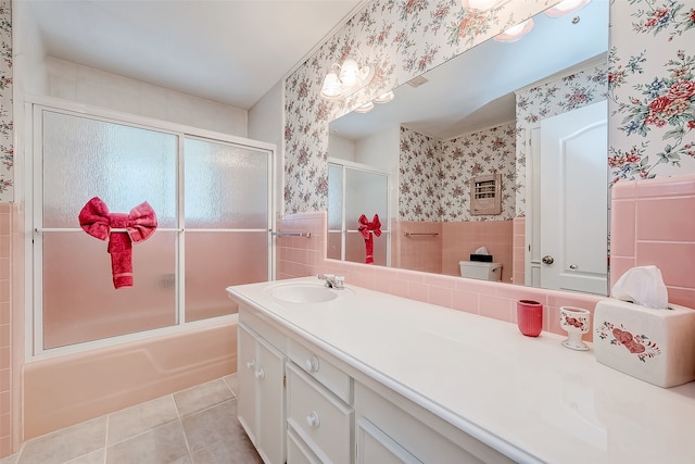 full bathroom with vanity, combined bath / shower with glass door, tile patterned flooring, toilet, and tile walls