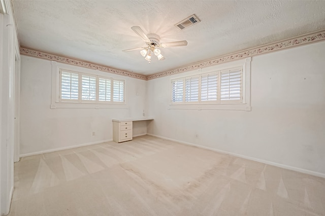 carpeted empty room featuring ceiling fan and a textured ceiling