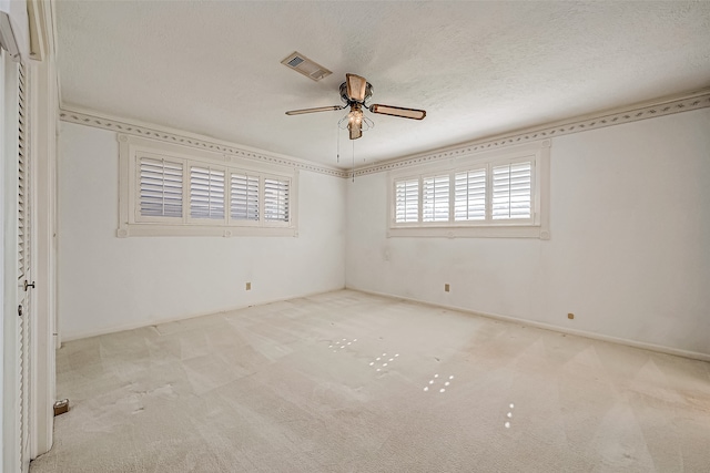 unfurnished bedroom with ceiling fan, light colored carpet, and a textured ceiling