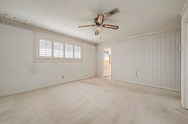 unfurnished room with a textured ceiling, ceiling fan, and light carpet