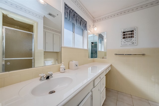 bathroom with tile patterned flooring, vanity, a shower with shower door, tile walls, and ornamental molding