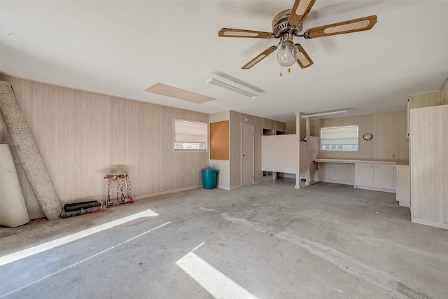 garage featuring white fridge, ceiling fan, and wooden walls