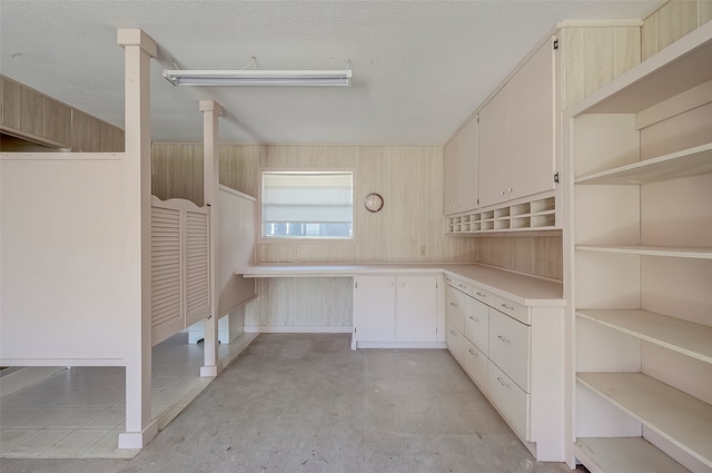 kitchen with wood walls and a textured ceiling