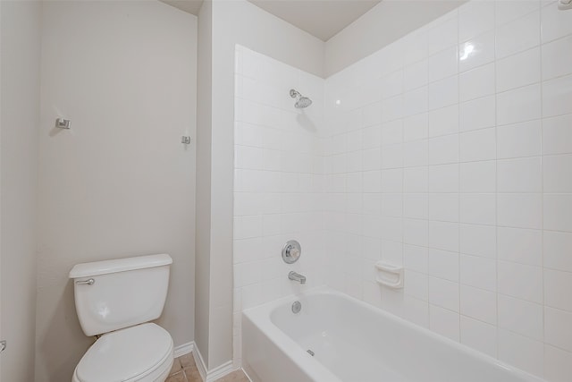 bathroom with tiled shower / bath combo and toilet