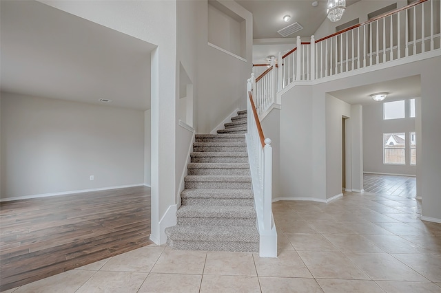 stairs featuring hardwood / wood-style floors and a high ceiling