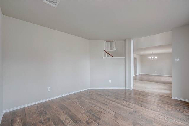 unfurnished room featuring light hardwood / wood-style flooring and a notable chandelier