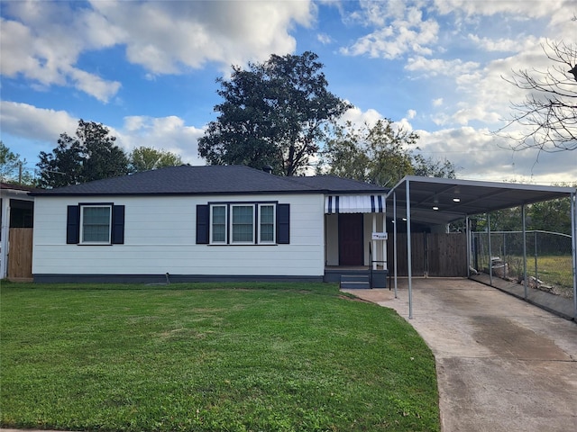 view of front of home featuring driveway, a shingled roof, a front yard, and fence