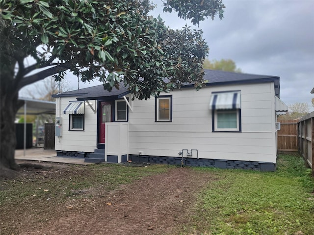 rear view of property with entry steps, a patio, fence, a yard, and crawl space