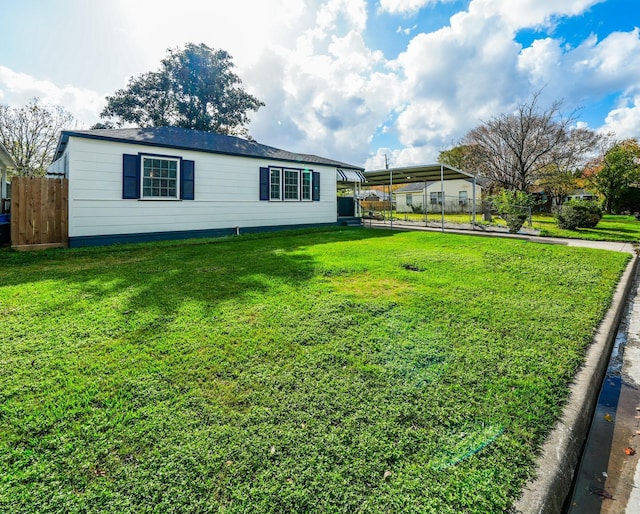 view of front facade featuring a carport, a front yard, and fence