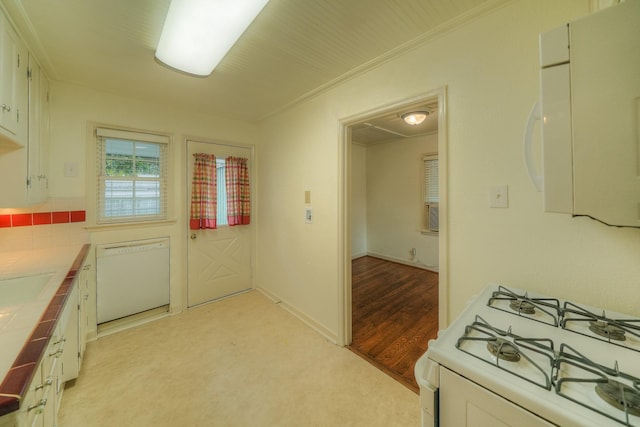 kitchen with light wood-type flooring, ornamental molding, white appliances, white cabinets, and tile counters