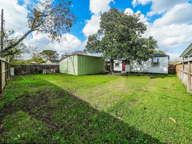 view of yard with a storage shed, an outdoor structure, and a fenced backyard