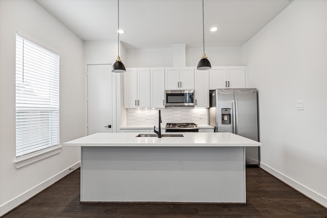 kitchen with appliances with stainless steel finishes, a wealth of natural light, and pendant lighting