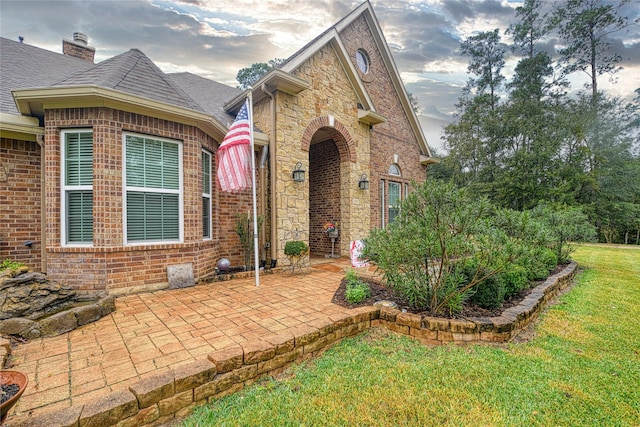 doorway to property featuring a patio and a yard