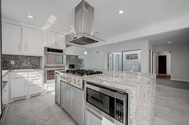 kitchen featuring island range hood, a kitchen island, white cabinetry, and stainless steel appliances