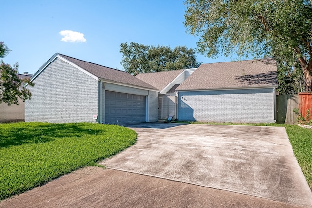 ranch-style home featuring a garage and a front yard