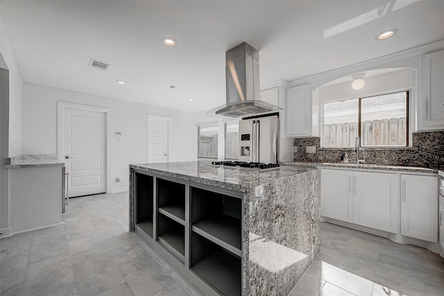 kitchen with white cabinetry, a center island, exhaust hood, and light stone counters