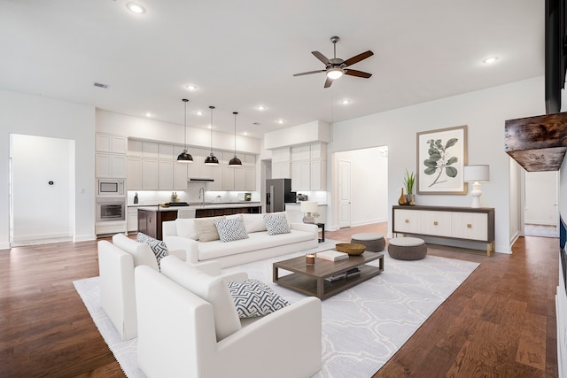 living room with ceiling fan, light wood-type flooring, and sink