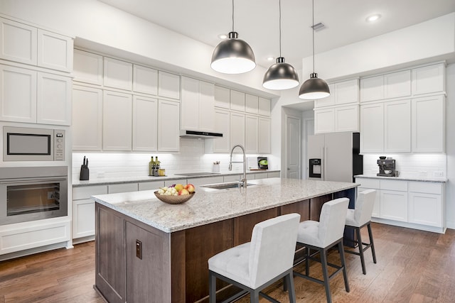 kitchen featuring pendant lighting, sink, dark hardwood / wood-style floors, an island with sink, and stainless steel appliances