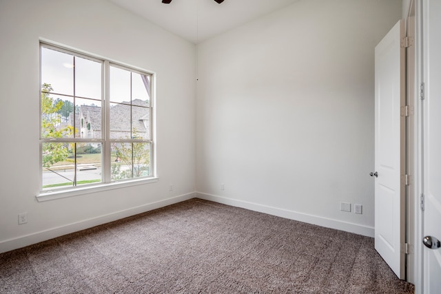 carpeted empty room with a wealth of natural light and ceiling fan