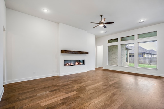 unfurnished living room with dark hardwood / wood-style floors and ceiling fan