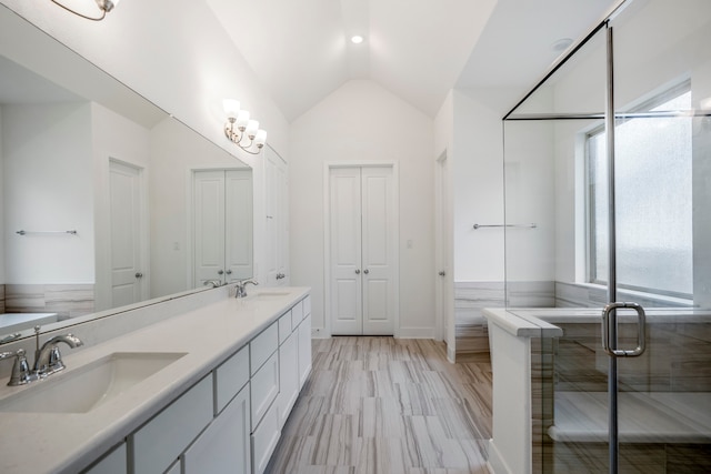 bathroom with vanity, lofted ceiling, walk in shower, and a healthy amount of sunlight