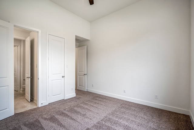 unfurnished bedroom featuring ceiling fan and light carpet