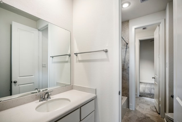 full bathroom featuring a textured ceiling, vanity,  shower combination, and toilet