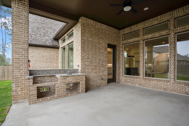 view of patio featuring ceiling fan and sink