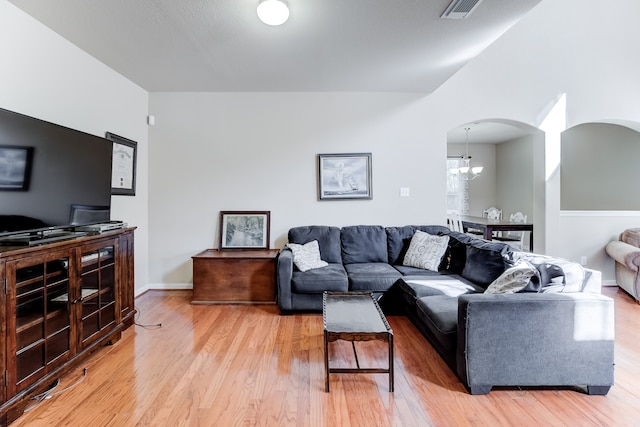 living room with a chandelier and light hardwood / wood-style floors