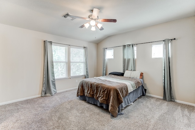 carpeted bedroom with ceiling fan, vaulted ceiling, and multiple windows