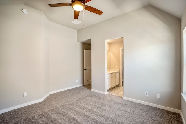 empty room featuring light carpet, vaulted ceiling, and ceiling fan