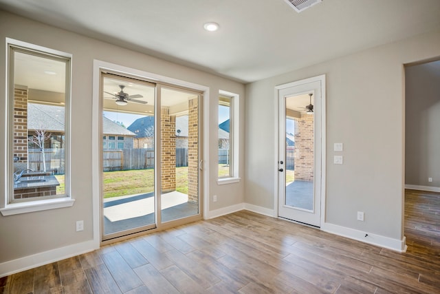 doorway to outside featuring hardwood / wood-style flooring, ceiling fan, and a wealth of natural light