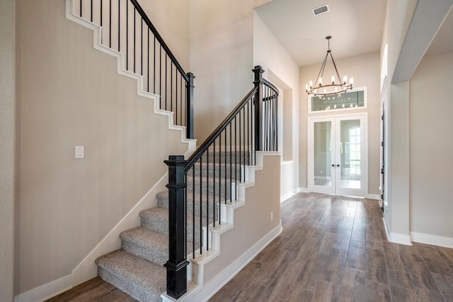 entryway with a chandelier, french doors, and wood-type flooring