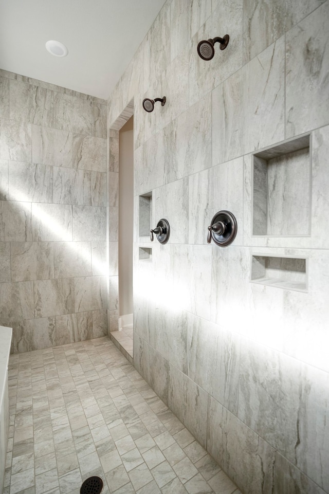 bathroom featuring tiled shower and tile walls