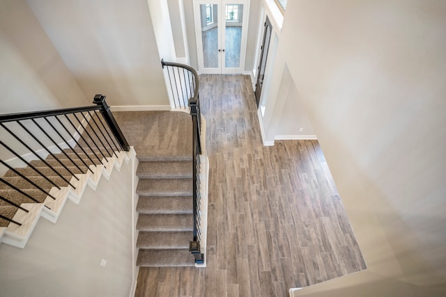 stairs featuring french doors and wood-type flooring