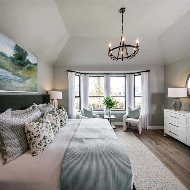 bedroom featuring a chandelier, hardwood / wood-style floors, and lofted ceiling