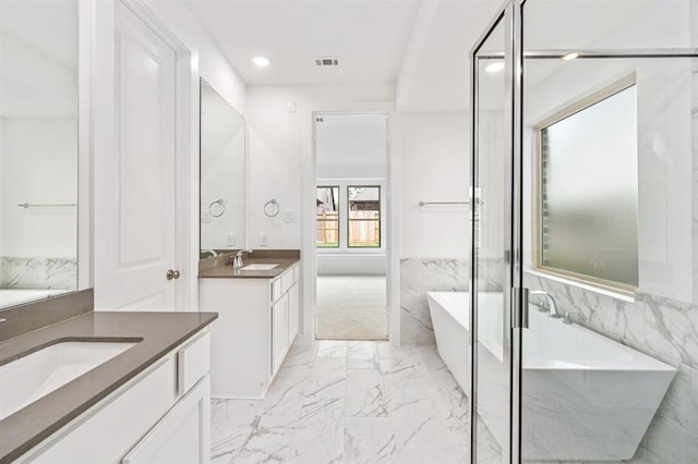 7427 Cattail Falls Ln, Porter, TX 77365 - full bath featuring marble finish floors, a freestanding bath, two vanities, recessed lighting, and a shower stall