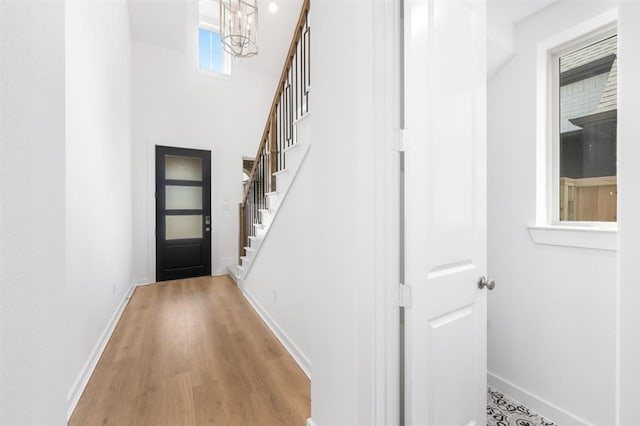 7427 Cattail Falls Ln, Porter, TX 77365 - entryway with a chandelier, baseboards, stairway, and light wood-style floors