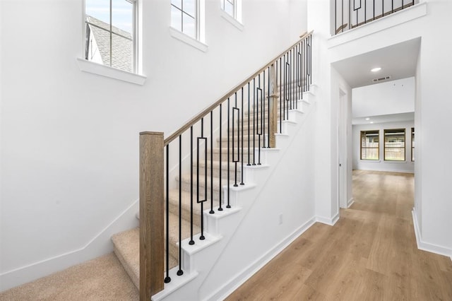 7427 Cattail Falls Ln, Porter, TX 77365 - stairway with wood finished floors, a towering ceiling, and baseboards